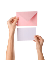 Fototapeta premium Hands holding pastel pink envelope and blank greeting card isolated on white background, minimal stationery mockup for invitation, wedding, message, correspondence and branding