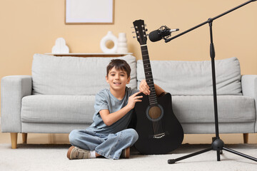 Cute boy with guitar and microphone sitting on floor at home © Pixel-Shot