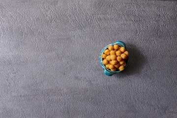 Assorted snacks in pottery bowls on grey background
