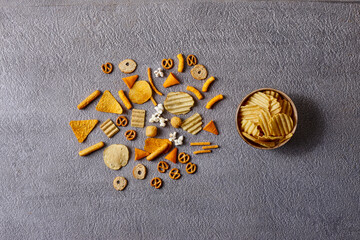 Assorted snacks in pottery bowls on grey background