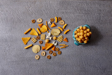 Assorted snacks in pottery bowls on grey background