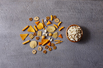 Assorted snacks in pottery bowls on grey background