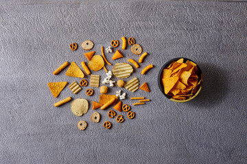 Assorted snacks in pottery bowls on grey background