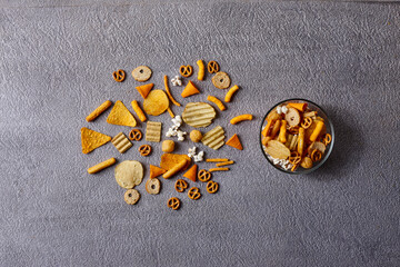 Assorted snacks in pottery bowls on grey background