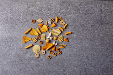 Assorted snacks in pottery bowls on grey background