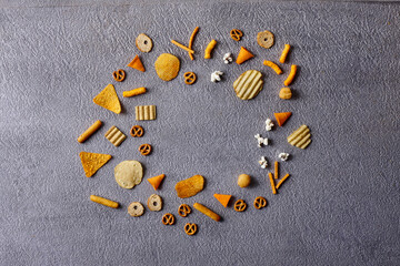 Assorted snacks in pottery bowls on grey background