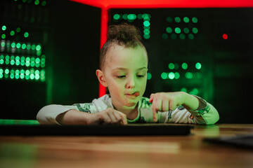 Young child concentrating on computer in server room