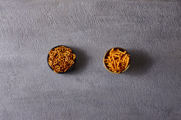 Assorted snacks in pottery bowls on grey background