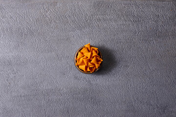Assorted snacks in pottery bowls on grey background