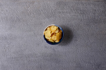 Assorted snacks in pottery bowls on grey background