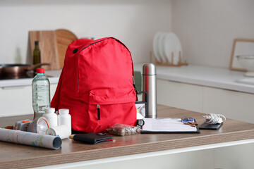 Emergency backpack with necessities on table in kitchen
