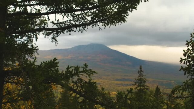 Footage capturing the serene and rugged beauty of the Southern Urals mountain range in Russia during the autumn season. The view, possibly near locations like the Urenga mountain range or Mount Yamant