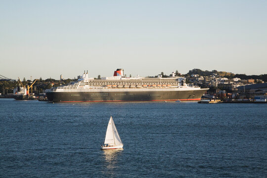 Queen Mary 2 cruise ship at Waitemata Harbour Auckland with sailboat