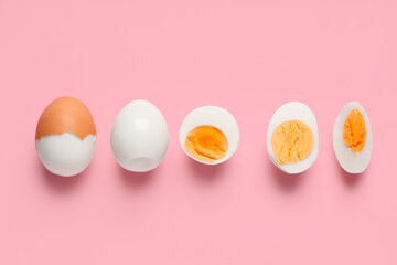 Row of fresh boiled eggs on pink background