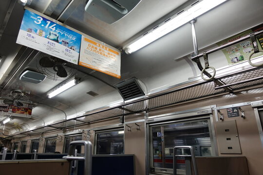 JR Hokkaido train featuring ceiling fans, mesh luggage racks.