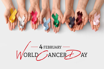Many female hands with different ribbons on light background. World Cancer Day