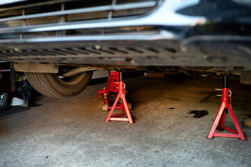 Pair of jack stands under the car during repair vehical. Safety oil changing. High quality photo