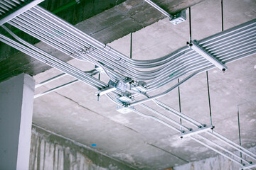 Industrial Conduit Network: An intricate network of metal conduits crisscrosses the ceiling, showcasing the essential infrastructure within a building, a testament to modern engineering.
