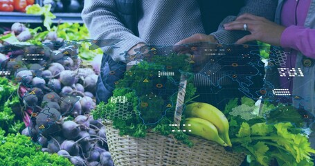 Holding wicker basket, gray-sweater, pink-coat couple showing greens bananas with AR map at market