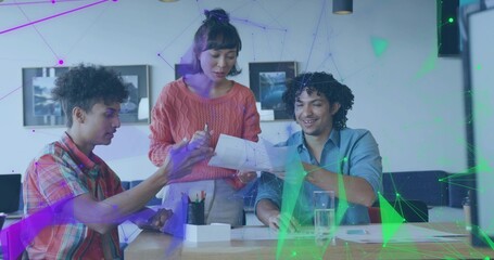 Reviewing small team at wooden table in office, woman in coral sweater holding papers, overlay