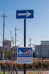 大阪府の条例に基づくアイドリングストップの啓発看板と一方通行の道路標識