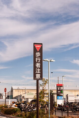 ショッピングモール駐車場の出口付近に設置された止まれと歩行者注意のオリジナルデザイン標識