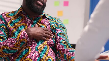 African Male Patient With Chest and Shoulder Pain Consulting Female Doctor in Hospital
