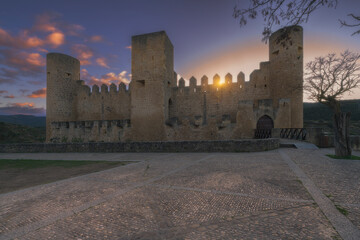Medieval castle of Frias at sunset with sun star behind battlements in Burgos Spain
