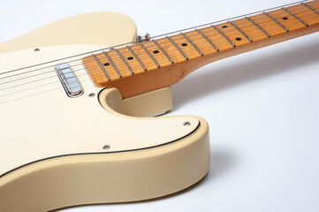 Six-string electric guitar, with a cream-colored wooden body and chrome-plated fittings.
