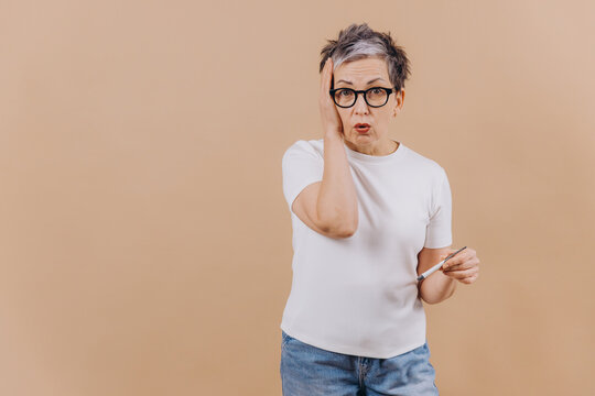 Senior woman reacting to high fever reading on thermometer
