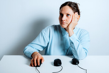 Multitasking office worker experiencing fatigue at desk with computer mice