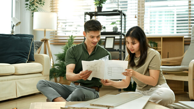Happy couple reading introduction assembly a new furniture at home