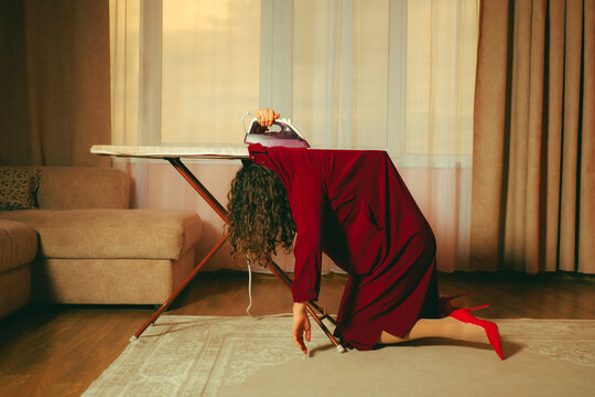 Exhausted woman in red dress overwhelmed by housework at home