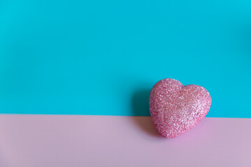 Glittery pink heart on pastel background for valentines day and love