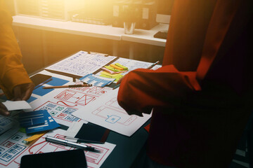 Team of uxui designers pointing at computer screen, discussing new mobile app design in the office