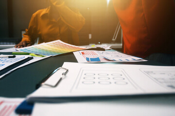 Team of uxui designers pointing at computer screen, discussing new mobile app design in the office