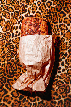 Pain au chocolat in brown paper on bold leopard pattern background
