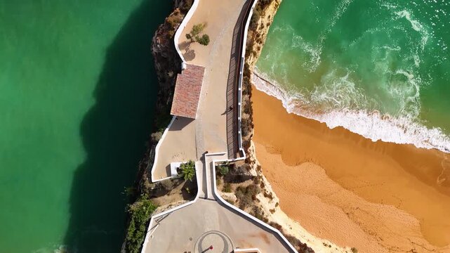 Direct Vertical Bird's Eye View of the Historic White Chapel of Nossa Senhora da Rocha on a Narrow Rocky Point in the Algarve Portugal Coast