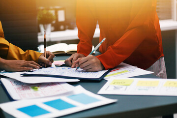 Team of uxui designers pointing at computer screen, discussing new mobile app design in the office