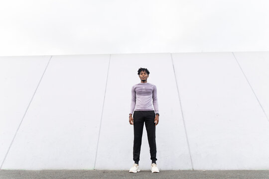 Athlete standing outdoors in urban setting with confident expression