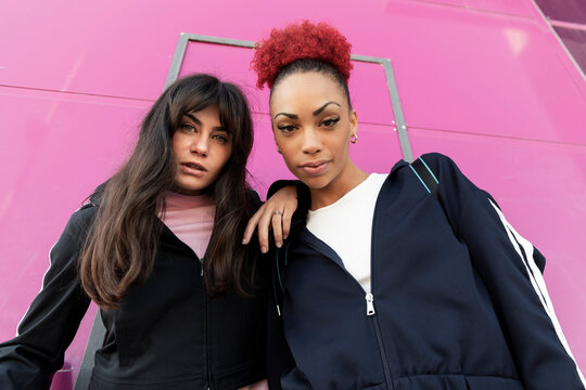 Young friends standing in front of purple wall