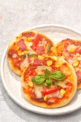 Homemade mini pizzas with smoked beef, tomatoes and mozzarella cheese