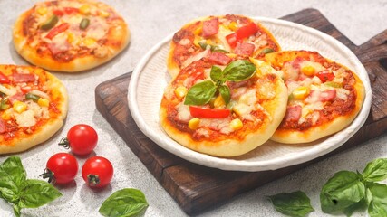 Homemade mini pizzas with smoked beef, tomatoes and mozzarella cheese