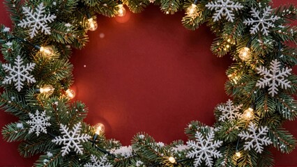 Christmas wreath with snowflakes and lights on red background