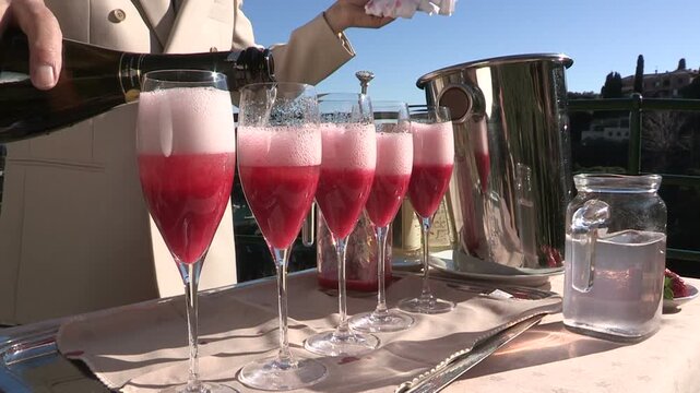 The barman adds champagne cocktails