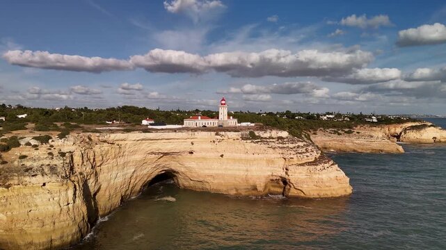 Aerial Rising Shot of Farol de Alfanzina Lighthouse on Sandstone Cliffs, Algarve, Portugal