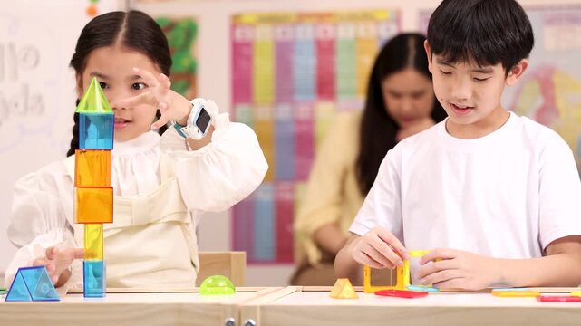 Elementary Students Building Colorful Geometry Towers in Classroom