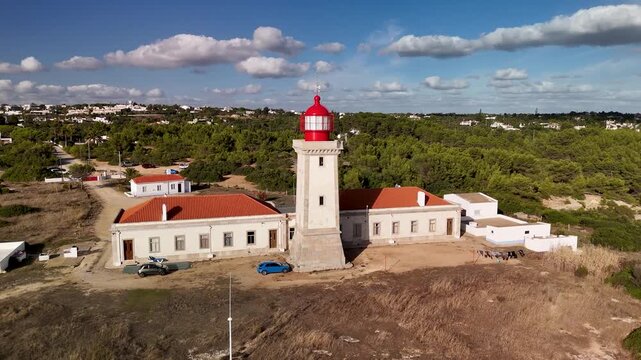 Drone Orbiting Farol de Alfanzina Lighthouse and Rugged Sandstone Cliffs, Algarve
