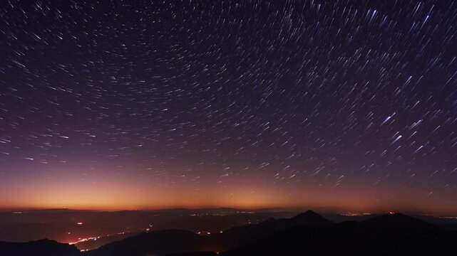 Night Sky Timelapse of Star Trails over Mountain Horizon