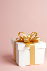 Obraz premium White gift box with shiny golden ribbon and bow on soft pink background, elegant present for celebration or special occasion with festive decoration and luxury wrapping